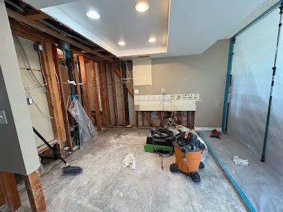 Kitchen opened to the studs inside plastic containment with a shop vacuum during water damage cleanup